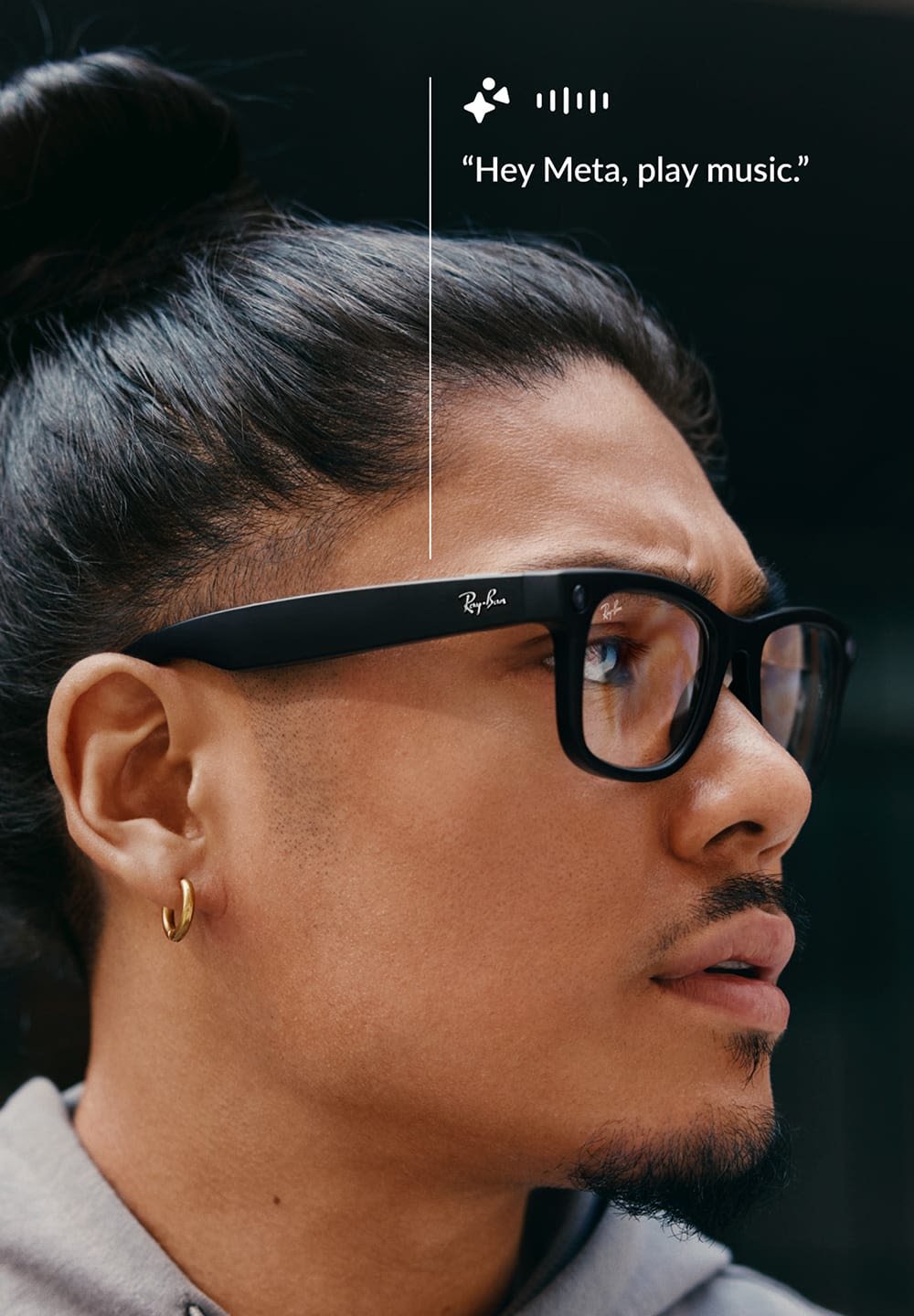 Lunettes intelligentes noires avec une monture rectangulaire, des verres transparents et un logo Ray-Ban. Une boucles d'oreille en or est visible près de l'oreille.