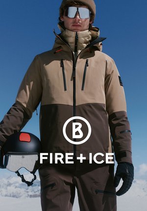 Beżowa i brązowa ocieplana kurtka narciarska z czarnymi suwakami i akcentami, w połączeniu z czarnym kaskiem i lustrzanymi goglami, na tle błękitnego nieba.