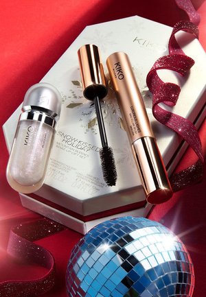 Zestaw prezentowy KIKO Snow-Kissed Holiday zawierający srebrną pomadkę w płynie, czarny tusz do rzęs oraz odblaskową kulę dyskotekową na czerwonym tle.