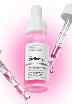Flacon compte-gouttes blanc avec un sérum rose, étiqueté "The Ordinary PHA 5% Exfoliating Lip Serum." Compte-gouttes transparent avec du liquide rose. Design simple.