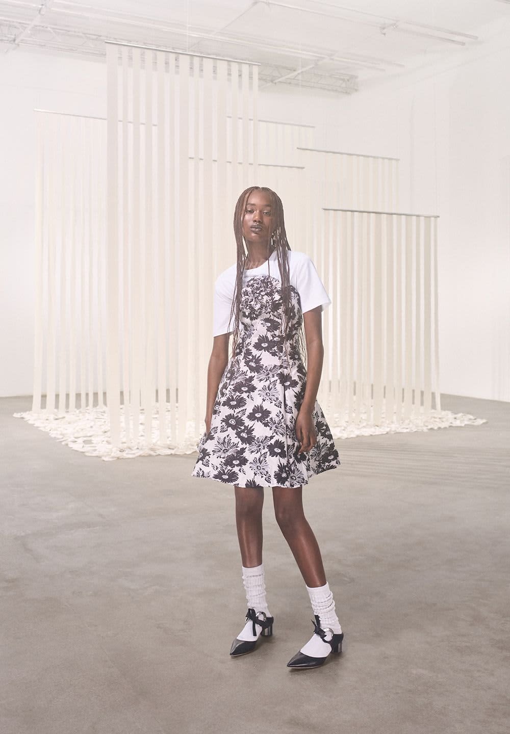 Black and white floral dress with a flared skirt, paired with a white t-shirt. Accessories include white knee-high socks and black heels.
