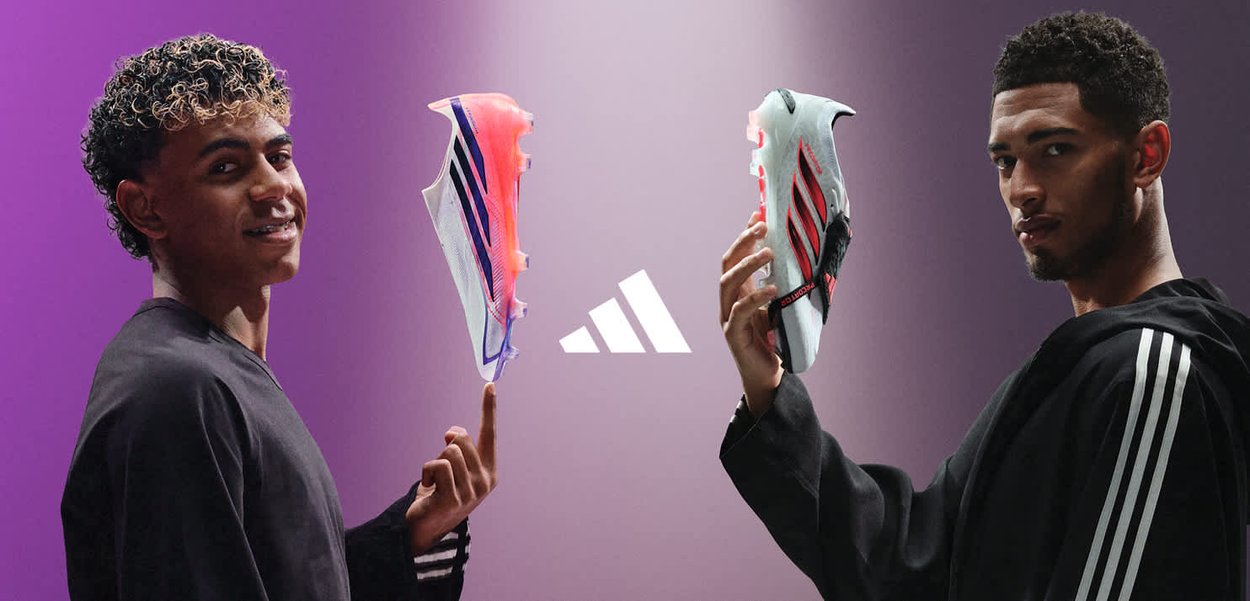 To mænd, der står over for hinanden, holder adidas fodboldstøvler op mod en lilla baggrund med adidas-logoet centreret mellem dem.