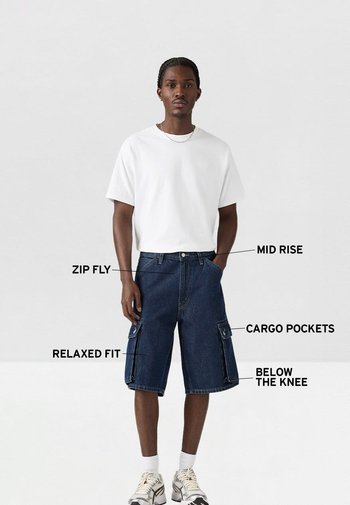 Pantalones cortos de mezclilla tipo cargo con un ajuste de altura media, cierre con cremallera, longitud por debajo de la rodilla y corte relajado. Presentan bolsillos cargo dobles a los lados.