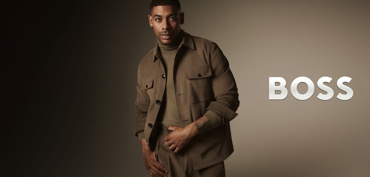 Brązowa bawełniana kurtka z zapięciem na guziki i kieszeniami na piersi, zestawiona z dopasowanym golfem. Prosty design na stonowanym tle.