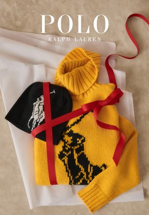 Žlutý pletený svetr s černým motivem koně, doplněný černou čepicí s bílým koněm. Oba jsou uvázány červenou stužkou.