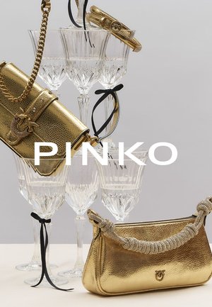 Borse dorate esposte su bicchieri di cristallo; superfici strutturate, tracolle intrecciate e a catena, con dettagli hardware prominenti.