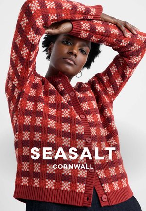 Cardigan tricoté à motif à carreaux rouge et crème, avec un col et des poignets côtelés, une fermeture à boutons sur le devant et une finition texturée.