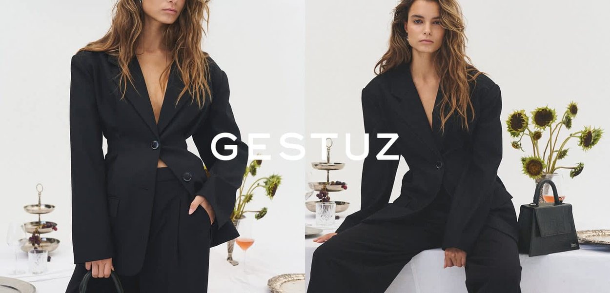 Zwarte op maat gemaakte blazer met een enkele knoopsluiting en lange mouwen, gecombineerd met bijpassende wijde broek. Heeft een gestructureerde silhoeët.