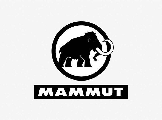 Silhouette neagră a unui mamut în interiorul unei contururi circulare, cu cuvântul "MAMUT" în litere negre îngroșate dedesubt, pe un fundal alb.