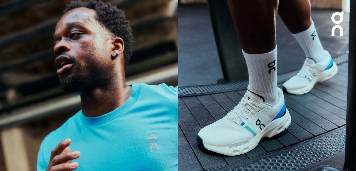 Homme portant une chemise bleu clair et des chaussures de course blanches avec des accents bleus, marchant sur un tapis de course à l'intérieur.