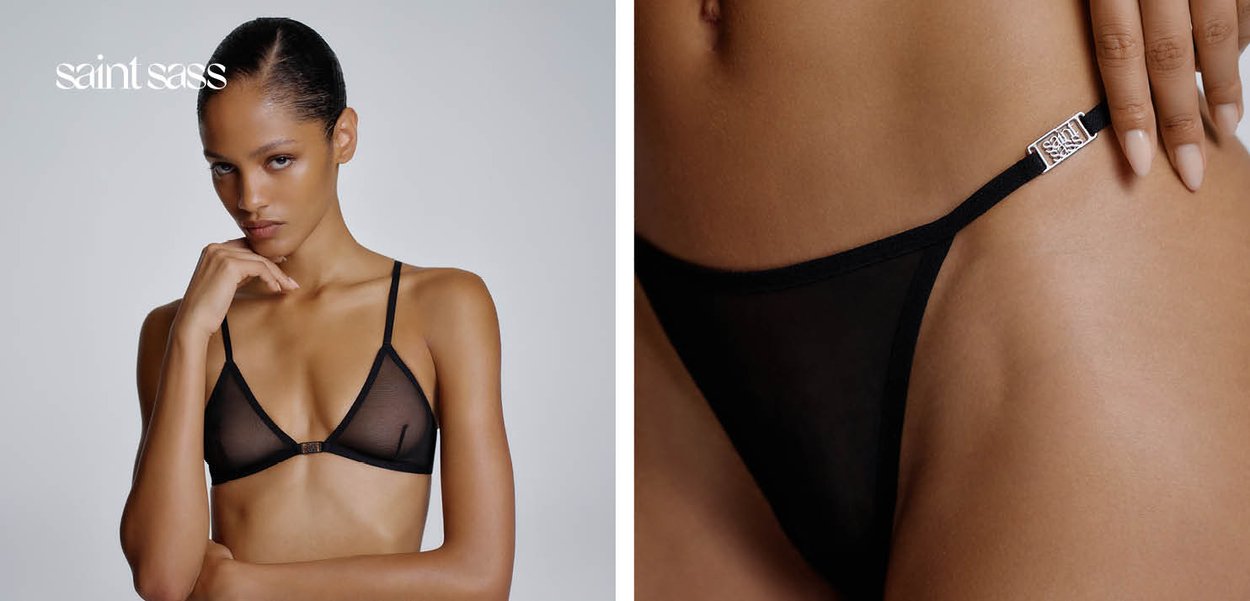Frau trägt transparenten schwarzen Bralette und passende Panties mit silbernem Verschlussdetail, posiert vor schlichtem hellem Hintergrund.