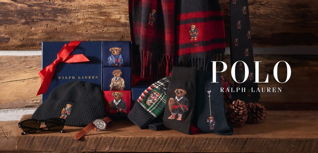 Accessori Polo Ralph Lauren con un berretto nero a maglia, sciarpe con motivi decorativi e una confezione regalo con nastro rosso, tutti rigorosamente con motivi orsetto.