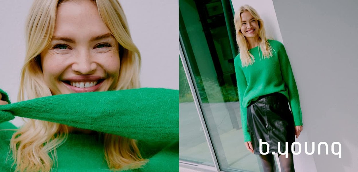 Grüner Strickpullover mit langen Ärmeln und einem lockeren Schnitt, kombiniert mit einem schwarzen Lederrock. Glatte Textur, kräftiger Farbkontrast.