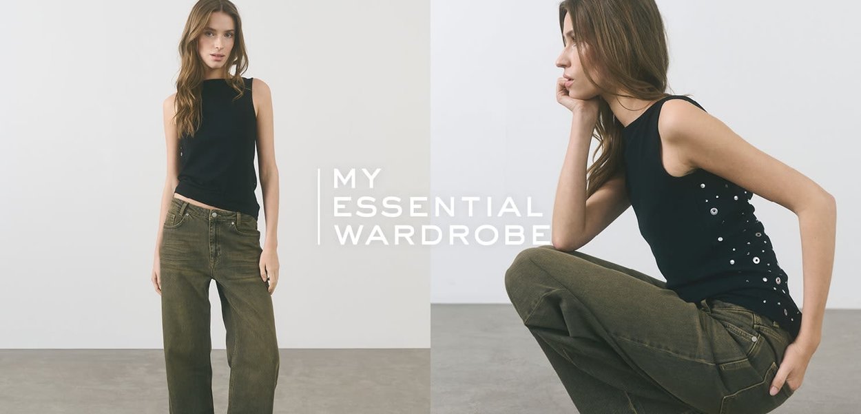 Black sleeveless top with button accents on the side, paired with olive green high-waisted wide-leg jeans. Simple, modern design.