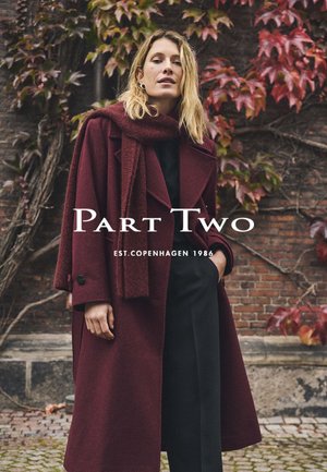 Burgundy wool coat with a double-breasted design and large lapels, paired with a matching textured scarf and a black outfit.