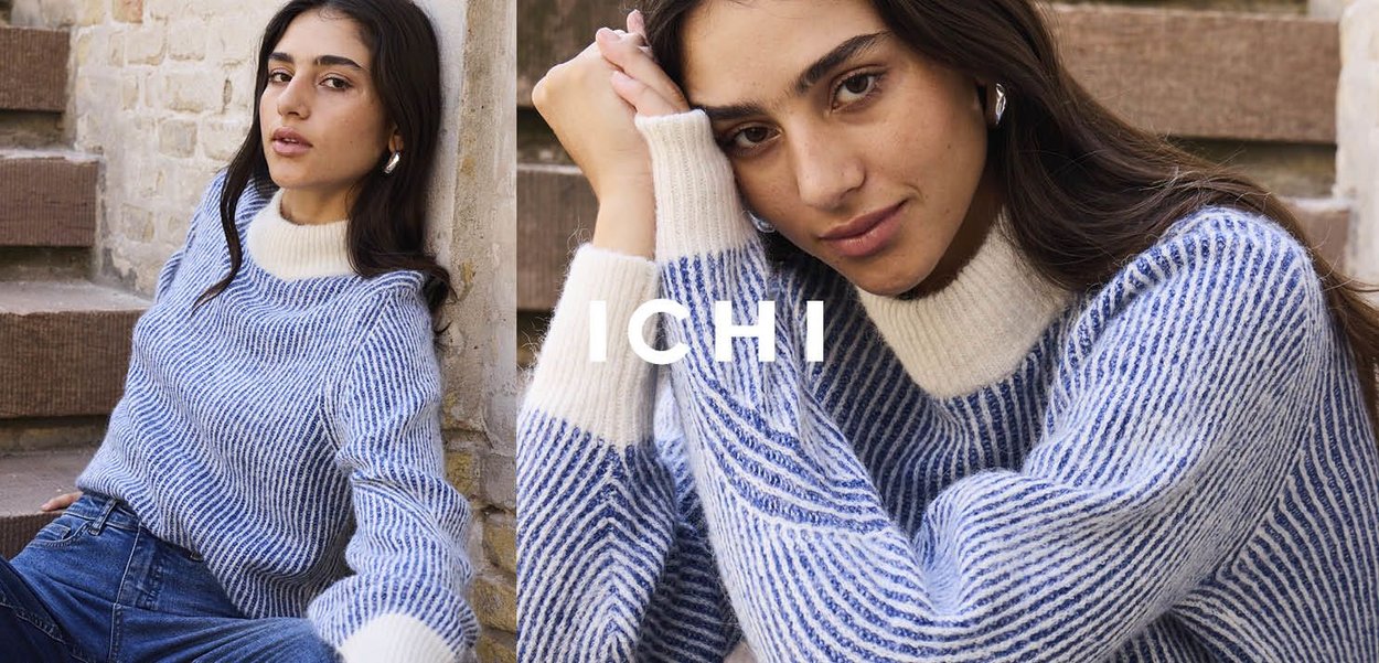 Maglione a righe blu e bianche in maglia con un colletto alto di colore chiaro. Il modello posa su scale con un'espressione rilassata.