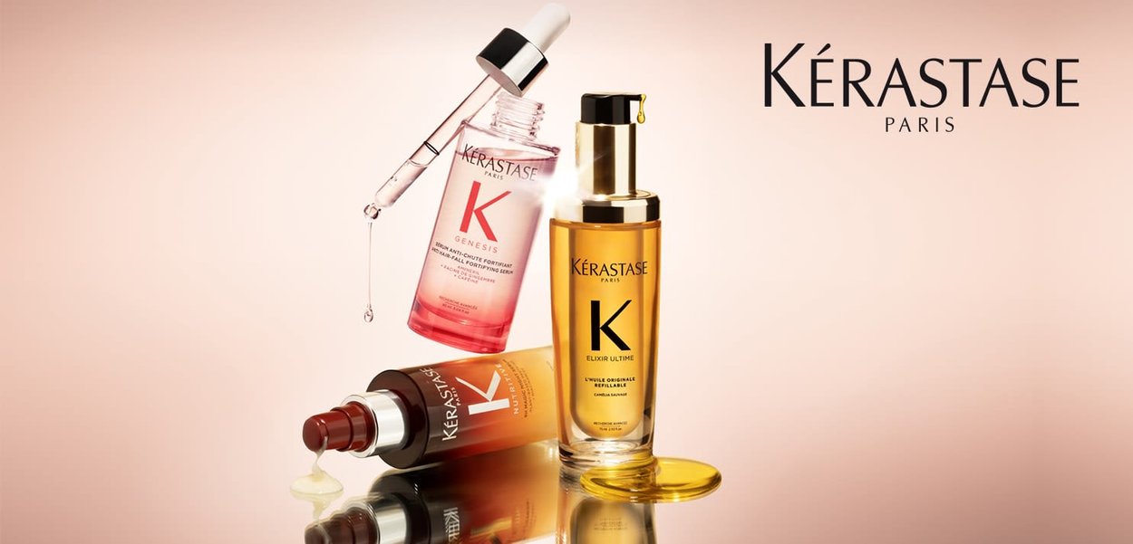 Kérastase hair care products displayed: a pink serum with dropper, a brown oil bottle, and a golden elixir, showcasing sleek glass designs.