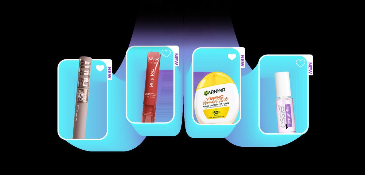 Quattro nuovi prodotti cosmetici esposti su piattaforme blu: mascara, lip gloss rosso NYX Jelly Job, crema solare Garnier alla Vitamina C e trattamento per unghie trasparente Essie.
