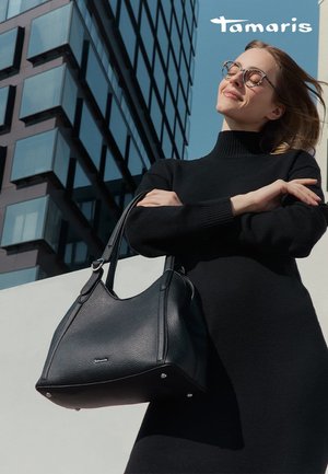 Sac à main en cuir noir au design structuré, avec quincaillerie en argent et rivets décoratifs. Ses doubles poignées robustes renforcent la fonctionnalité.