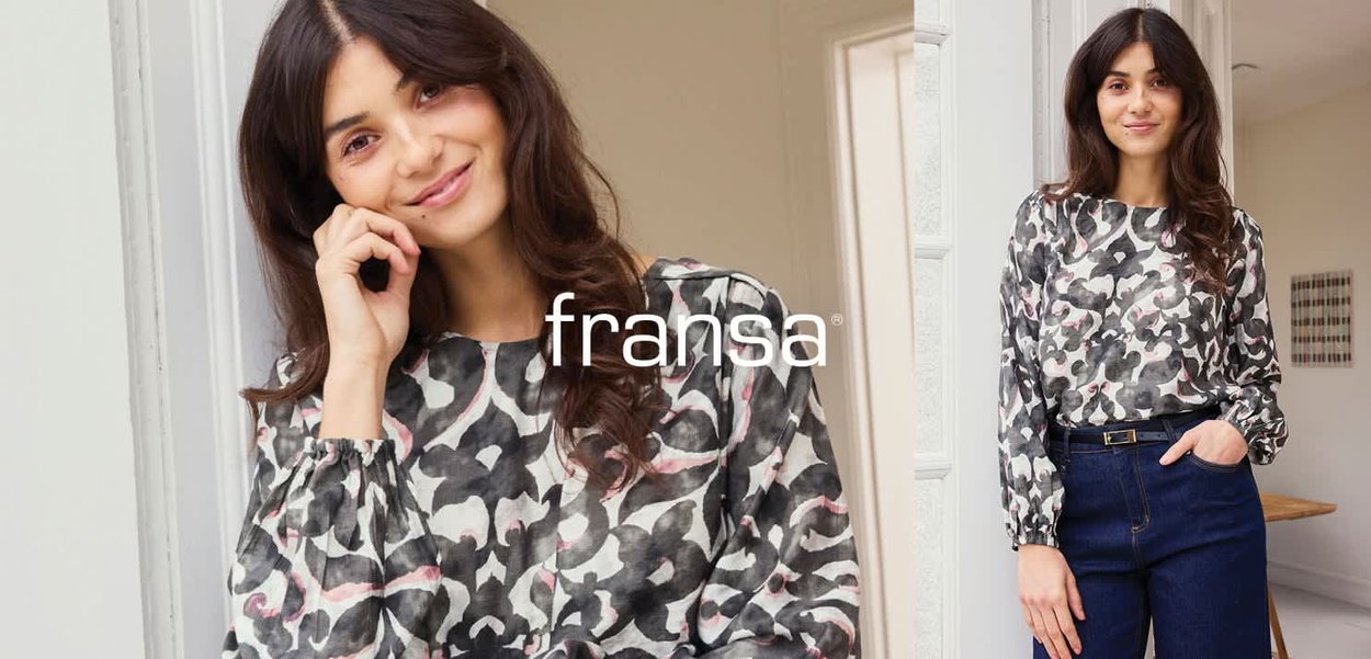 Bluse mit Blumenmuster in Grau, Schwarz und Rosa mit Puffärmeln und rundem Ausschnitt, kombiniert mit hoch taillierten, dunklen Jeans aus Denim.