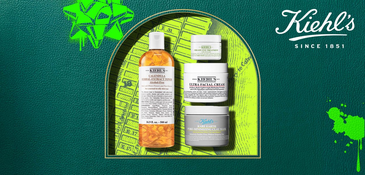 I prodotti per la cura della pelle di Kiehl's includono una bottiglia arancione di tonico all'estratto di erbe e tre barattoli bianchi etichettati per crema viso, trattamento per gli occhi e maschera di argilla.