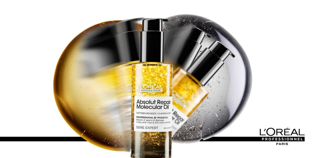 L'Oréal Professionnel Absolut Repair Molecular Oil in einer klaren Flasche, mit einer schwarzen Pumpe, gefüllt mit goldener Flüssigkeit und Blasen.
