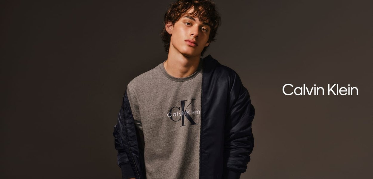 Grauer Sweatshirt mit marineblauen Akzenten, ausgestattet mit dem "Calvin Klein"-Logo und den "CK"-Initialen. Weicher Stoff, lässiges Design, runder Ausschnitt.