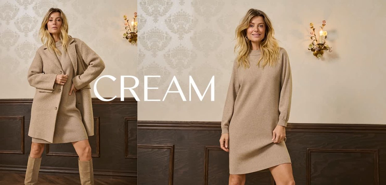 Cremiger Wollmischmantel und Strickkleid, beide mit einer strukturierten Oberfläche. Der Mantel hat große Knöpfe und eine lockere Passform. Neutrale Farbtöne dominieren.