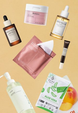 Verschillende huidverzorgingsproducten op een beige achtergrond: olie, tonerpads, serums, sheetmaskers en reinigingsolie, met een mix van glas- en folieverpakkingen.