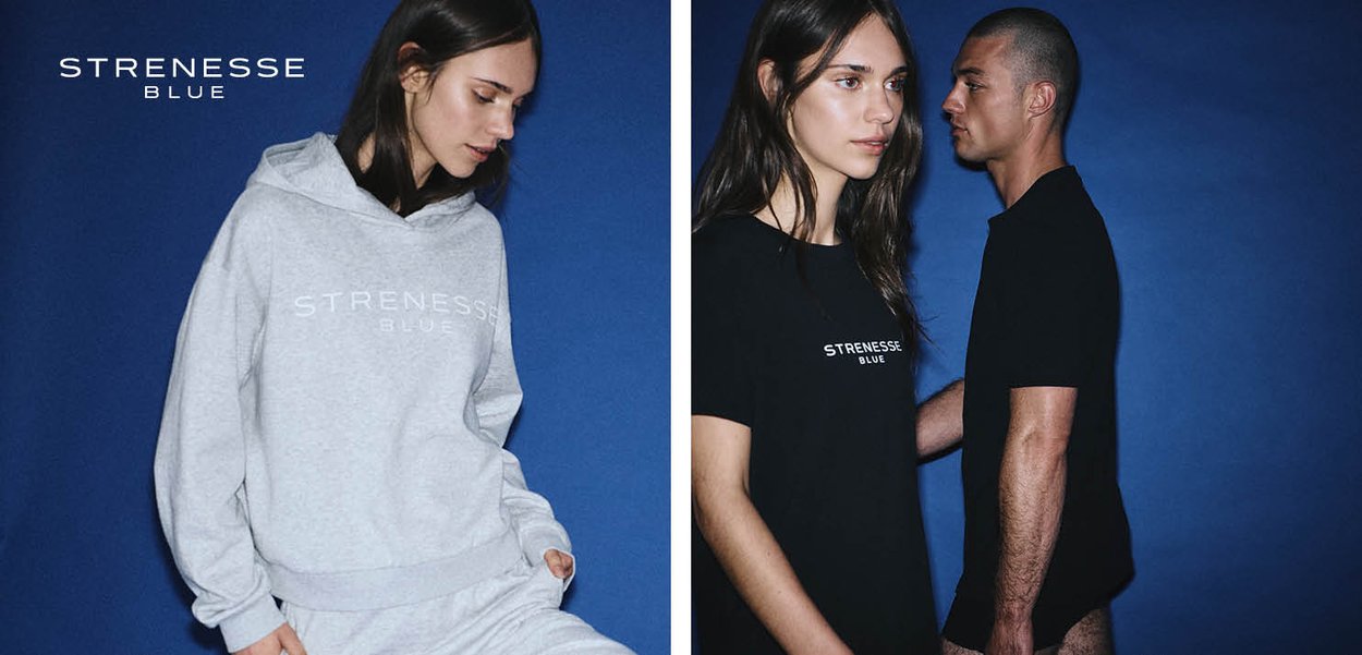 Frau in hellgrauem Hoodie und Jogginghose mit "Strenesse Blue"-Logo sowie Frau und Mann in schwarzen "Strenesse Blue"-Shirts vor blauem Hintergrund.