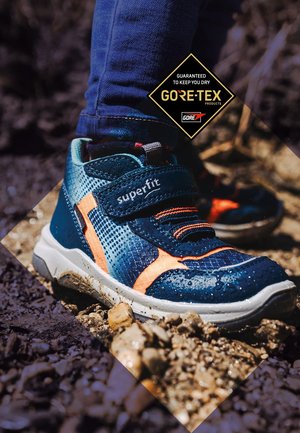Wasserdichte blaue Sneaker mit orangefarbenen Akzenten, texturiertem Mesh-Obermaterial, Klettverschluss und weißer Sohle, entwickelt für aktive Freizeit im Freien.