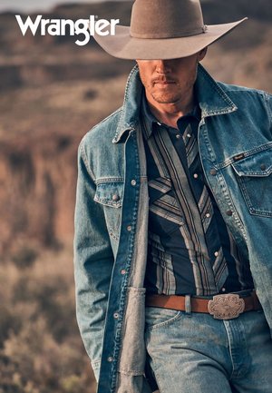 Denimjakke med vestlig design, kombinert med en blåstripet skjorte og en sølvspenne på beltet. En bredbremmet hatt fullfører antrekket.