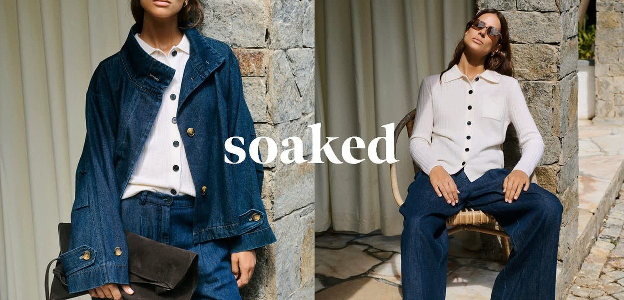 Jeansjacke mit goldenen Knöpfen und lockerem Schnitt, kombiniert mit einem gerippten cremefarbenen Cardigan mit schwarzen Knöpfen, dazu weite Jeanshosen.