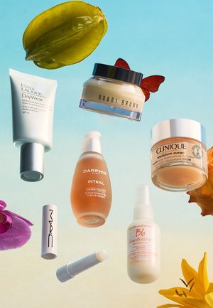 Productos de cuidado de la piel y maquillaje flotando, incluyendo Estee Lauder, Bobbi Brown, Clinique, Darphin, MAC y Bumble and bumble sobre un fondo azul.