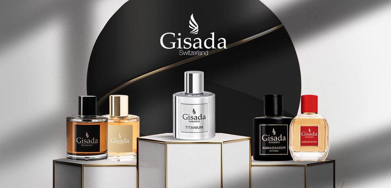 Profumi Gisada esposti su supporti geometrici: cinque flaconi con forme, colori (nero, oro, argento, rosso) e etichette distinti, posizionati su uno sfondo sfumato.