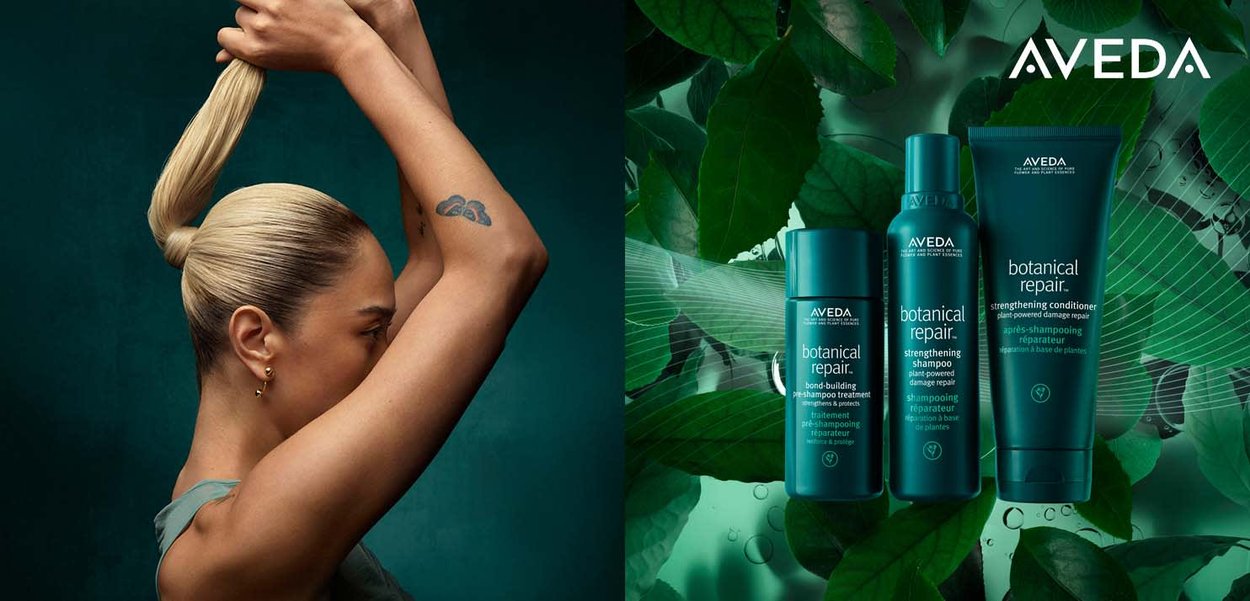 Aveda Botanical Repair trio in turquoise verpakking: een versterkende shampoo, een bindend behandelmiddel en een conditioner, omringd door groene bladeren.