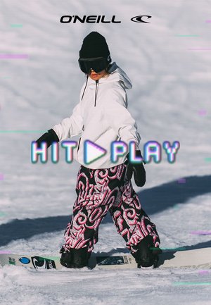 Kind draagt witte jas, zwarte handschoenen en gebloemde broek, snowboardt op besneeuwde helling met O'Neill-logo erboven en tekstoverlay "HIT PLAY".