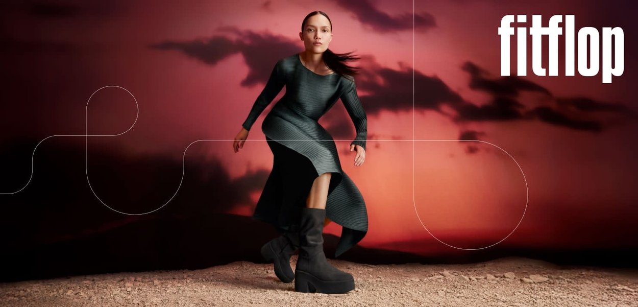 Schwarze Plateaustiefel mit strukturiertem Finish, kombiniert mit einem eng anliegenden, dunkelgrünen, gerippten Kleid mit langen Ärmeln und einem Seitenschlitz.