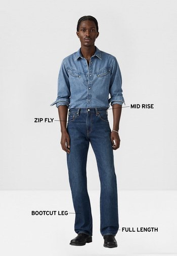 Camisa vaquera en azul claro con cierre de botones y dos bolsillos en el pecho; vaqueros bootcut en azul oscuro con cintura de altura media y detalle de cremallera.