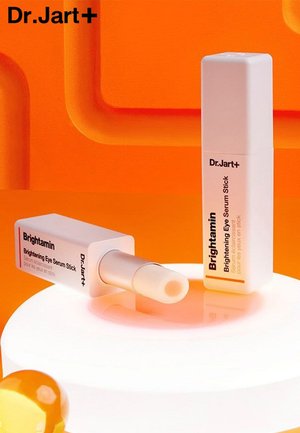 Stick de sérum éclaircissant pour les yeux Brightamin de Dr. Jart+, contenant cylindrique blanc avec des accents orange, applicateur à rotation, finition lisse.