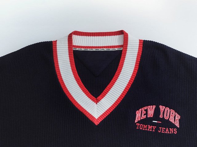 Navy ribbed jumper with a white and red striped V-neckline. Features "NEW YORK" and "TOMMY JEANS" embroidered in red.