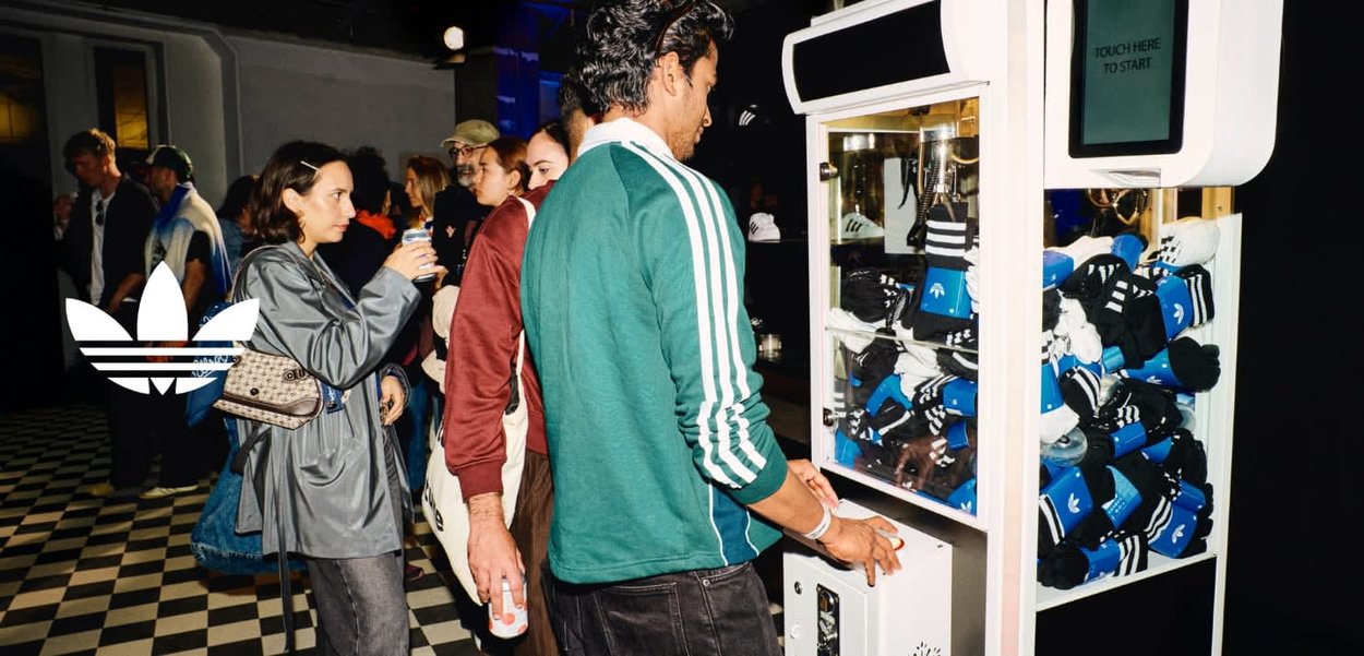Socks vending machine features a white frame with a touch screen. Socks are blue and black with stripes, packed neatly inside.