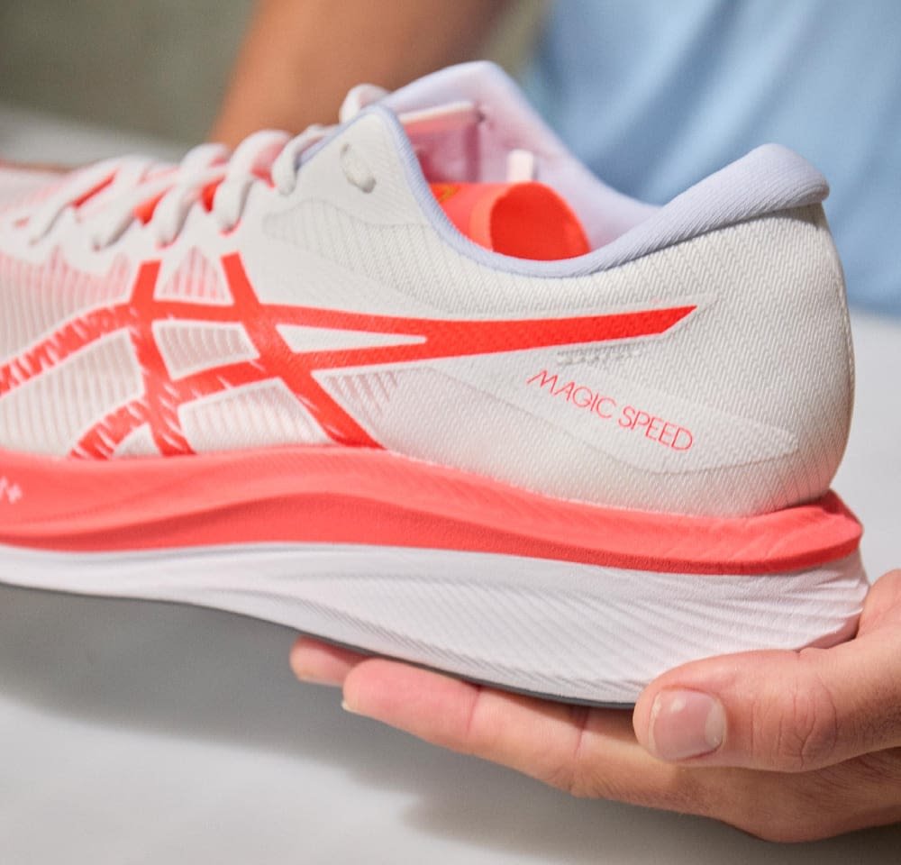 Sportlicher Schuh in Weiß und leuchtendem Koralle, mit leichtem Mesh-Obermaterial, gepolsterter Sohle, strukturierten Mustern und "MAGIC SPEED"-Detail.