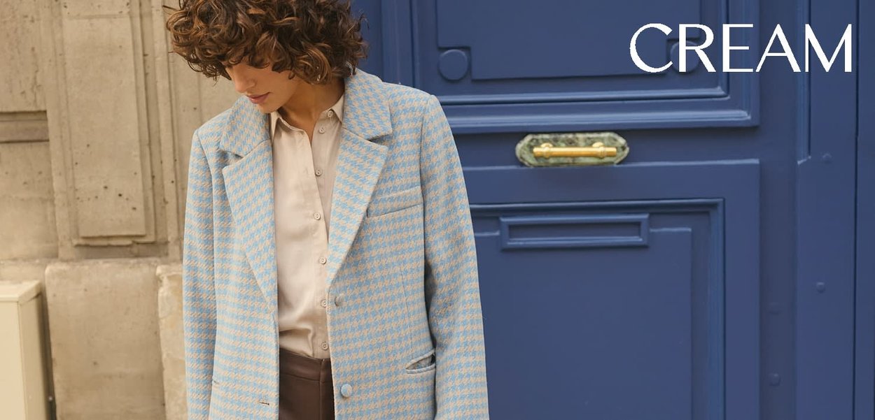 Cremefarbener Hundszahn-Blazer mit blauen Akzenten, einreihigem Schnitt, abgestepptem Revers und Tasche vorne; kombiniert mit einem hellbeigen Hemd.