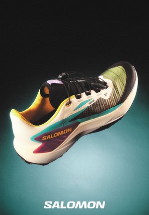 Salomon Laufschuh mit einem Obermaterial aus weißem und schwarzem Mesh, bunten Akzenten, einer strukturierten Sohle und einem markanten Design.