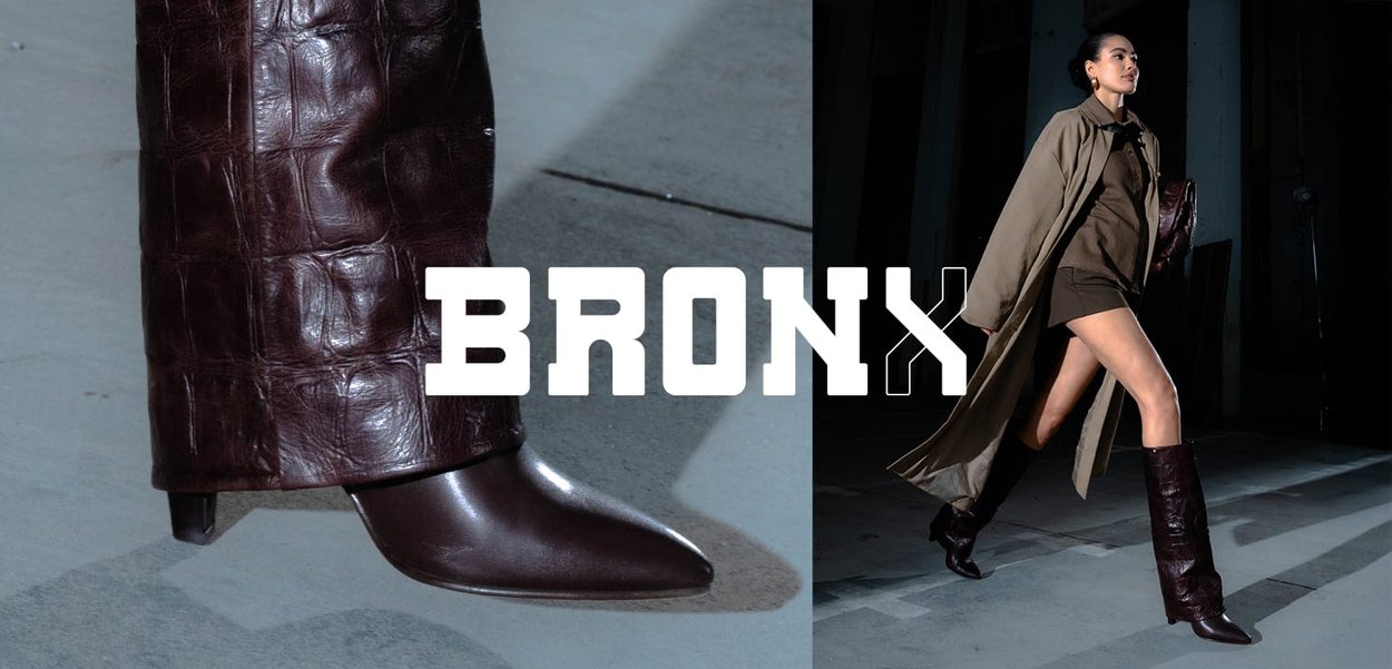 Brown leather high-heeled boots featuring a patterned texture with a pointy toe and knee-high design, paired with an oversized coat.