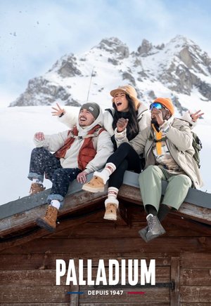 Drei Personen sitzen auf einem Dach und tragen Winterkleidung: eine braune Weste, eine graue Jacke, einen senfgelben Hut und beige Stiefel, mit Schnee und Bergen im Hintergrund.
