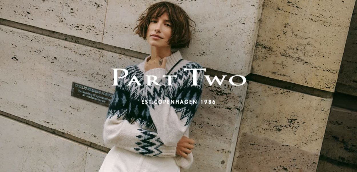 Knit sweater in cream with blue geometric patterns, featuring a v-neck and long sleeves. Text overlay includes "Part Two" and brand details.