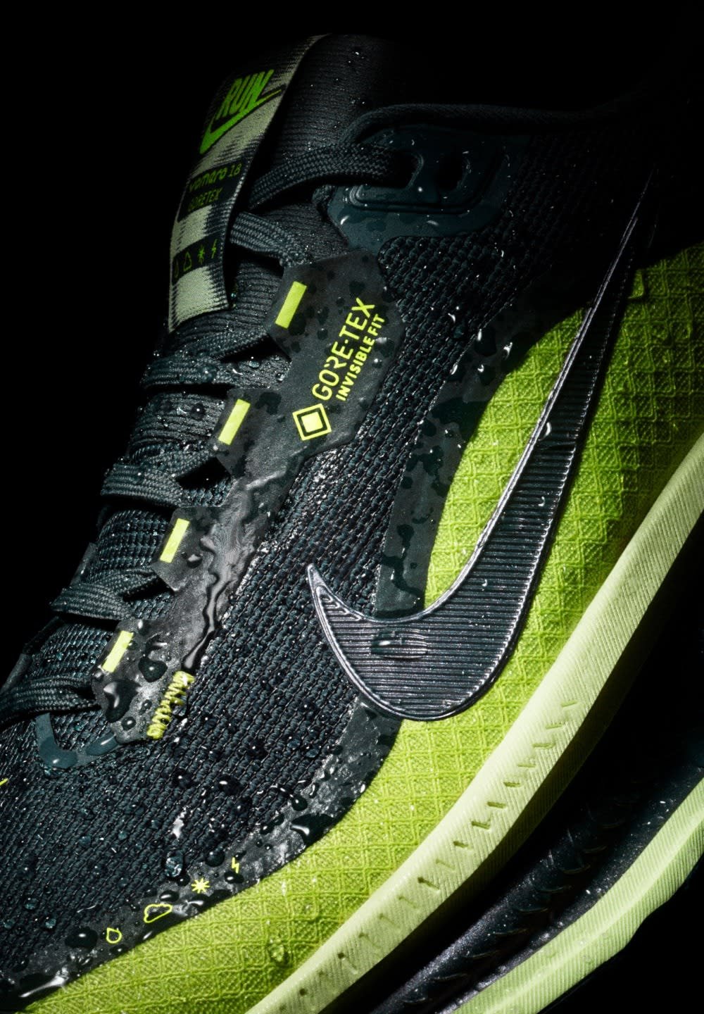 Baskets noires et vert fluo avec une surface texturée, étiquette GORE-TEX, gouttes d'eau sur le tissu, et le logo distinctif de Nike Swoosh.