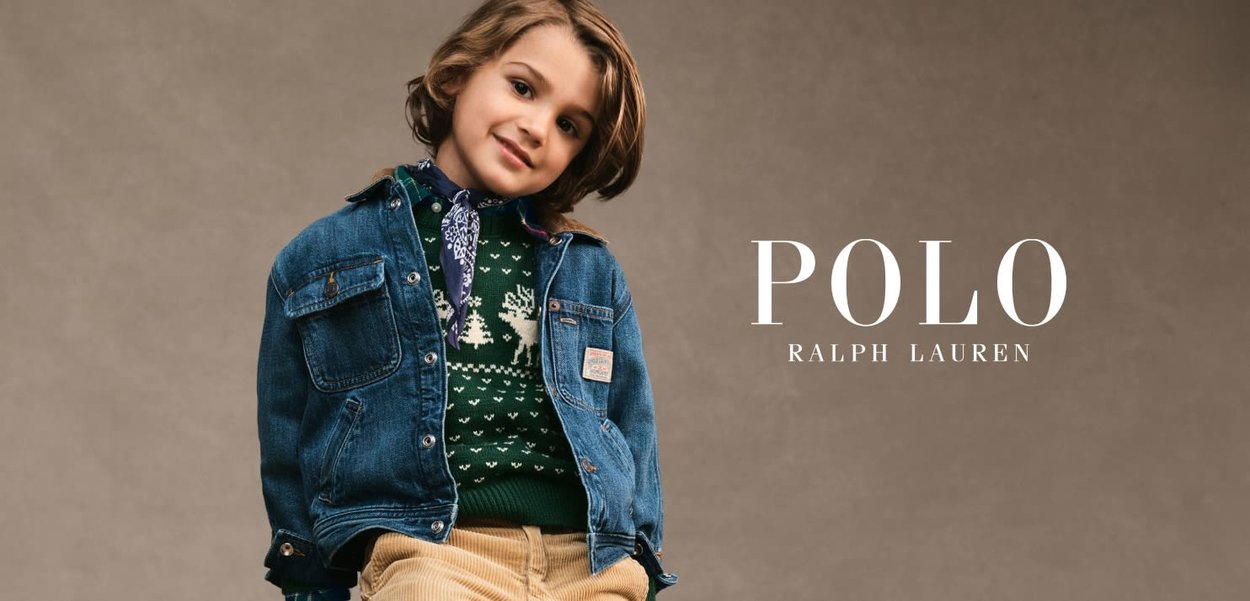 En denimjakke over en grøn strikket trøje med mønster. Beige kordfløjspants. Blå bandana. Bløde teksturer, afslappet design, jordnært farvepalet.